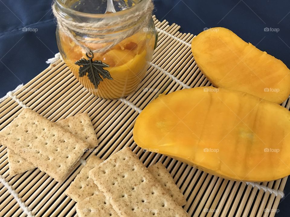 Mango jam with crackers on bamboo plate mat 