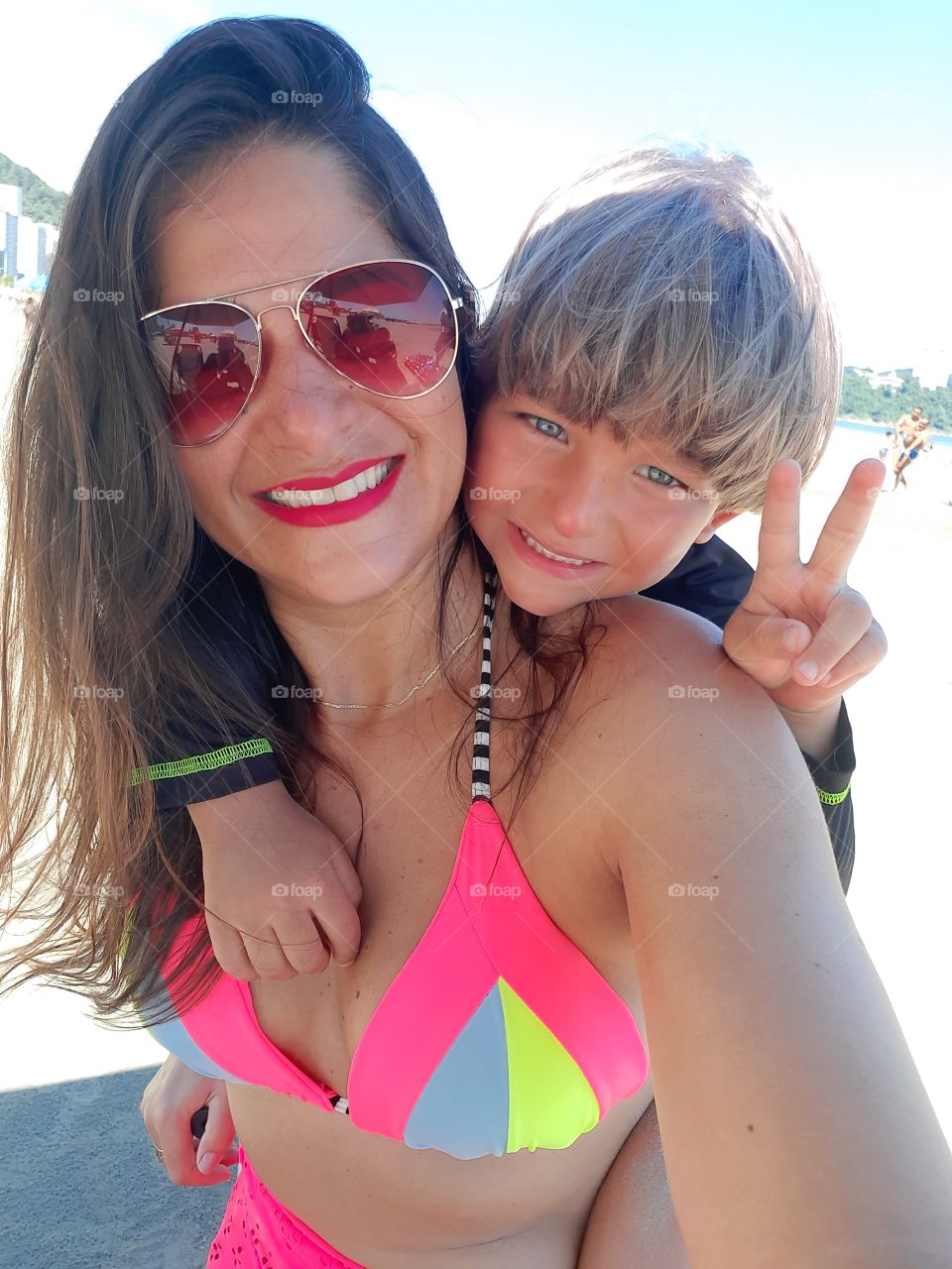 blond boy and mother on the beach in Santos smiling