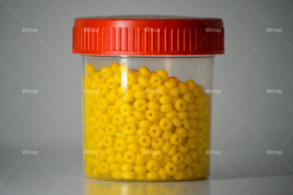 a jar of yellow beads that I use to make necklaces