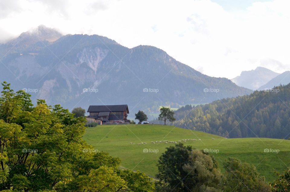 House on the green hill. House on the green hill at Val di Funes with mountains background 