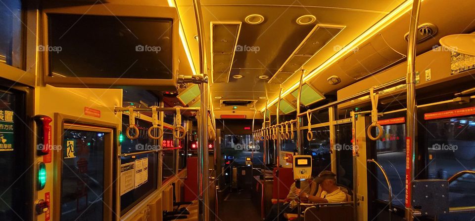 A retro-style bus with a warm yellow light interior. The marquee reads "Please pay attention to safety while driving" in Chinese