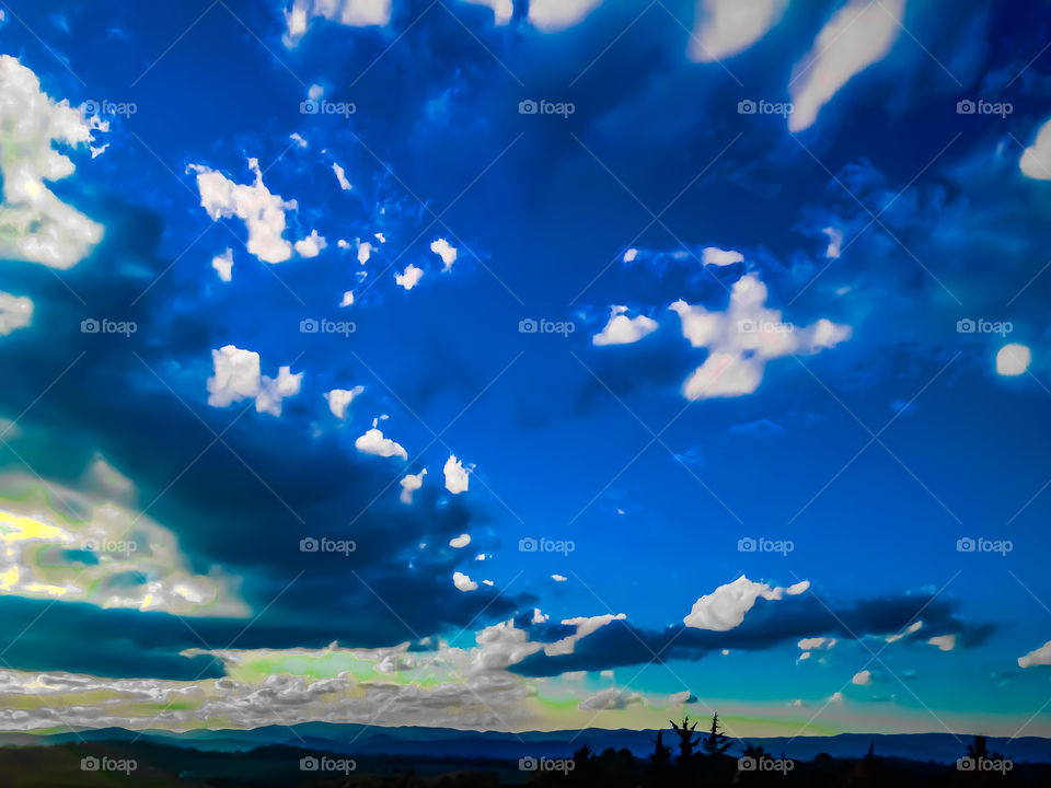 Gorgeous clouds in a remarkably blue sky as the sun is setting