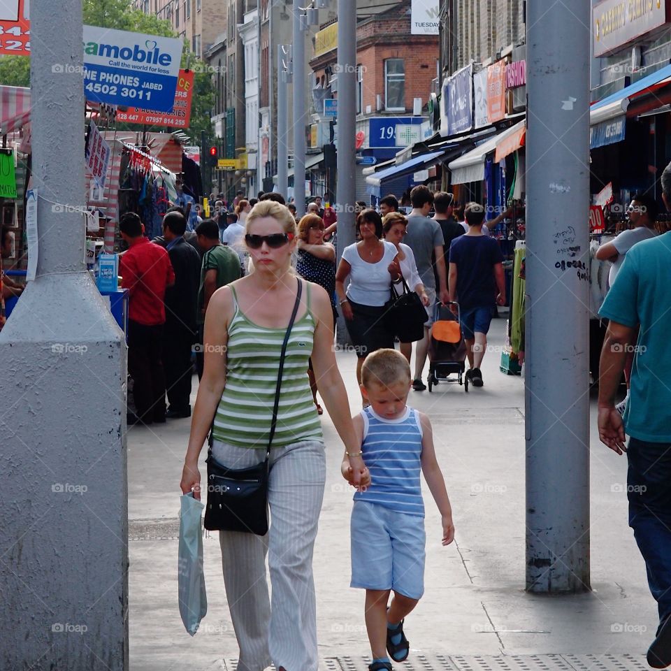 Crowds of people out walking and shopping on London streets in Europe on a summer day. 