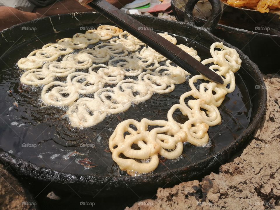 Famous Indian street sweet jalebi, It is made by deep-frying maida flour, circular shapes, which are then soaked in sugar syrup. They are particularly popular in the Indian subcontinent and Iran.