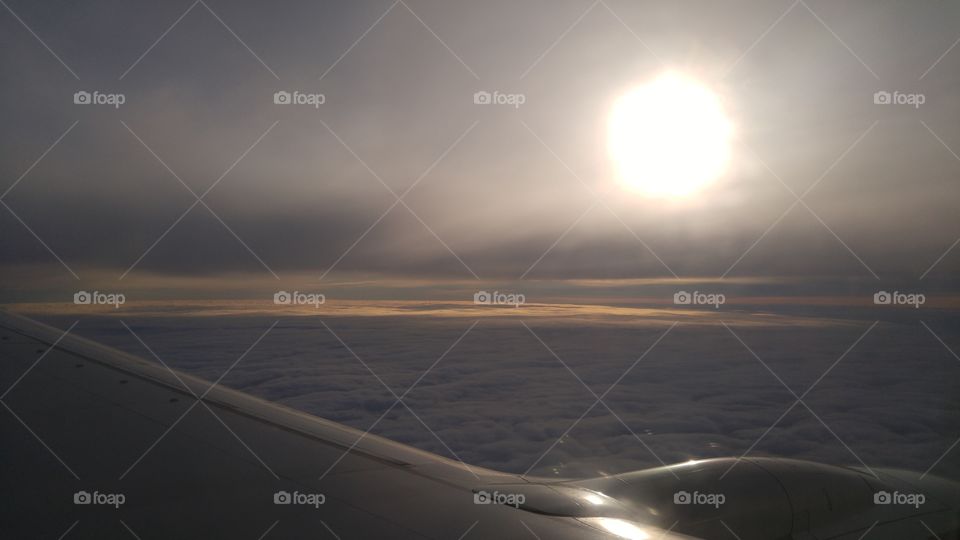 A view from a plane window flying high abowe the clouds.