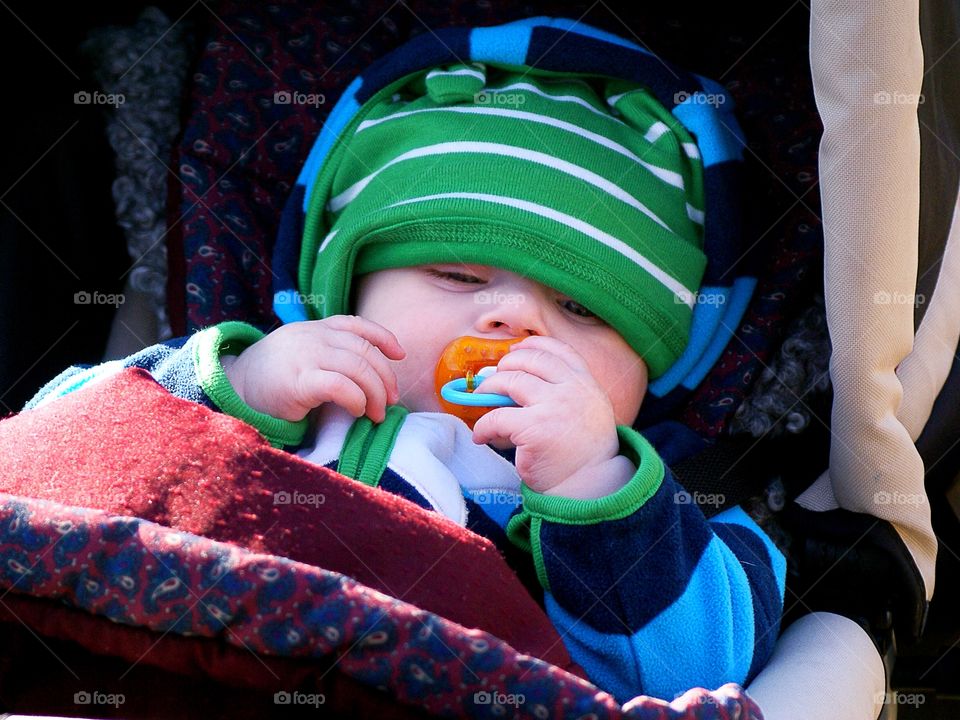 Baby laying outdoors in the stroller