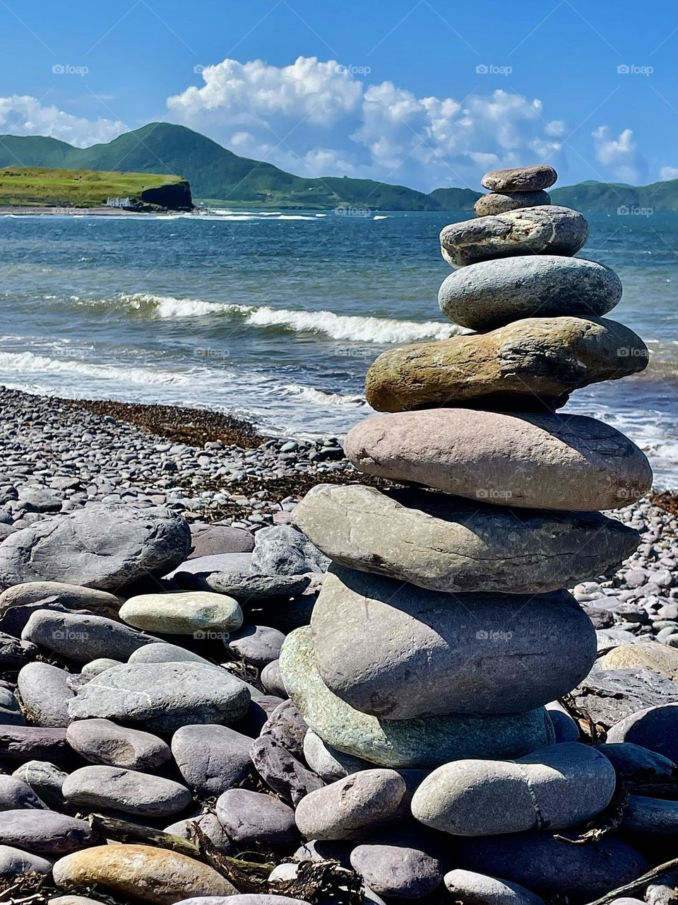 “Cairn”.  Stacked stones overlook the rocky beach in Waterville, Co. Kerry, Ireland.