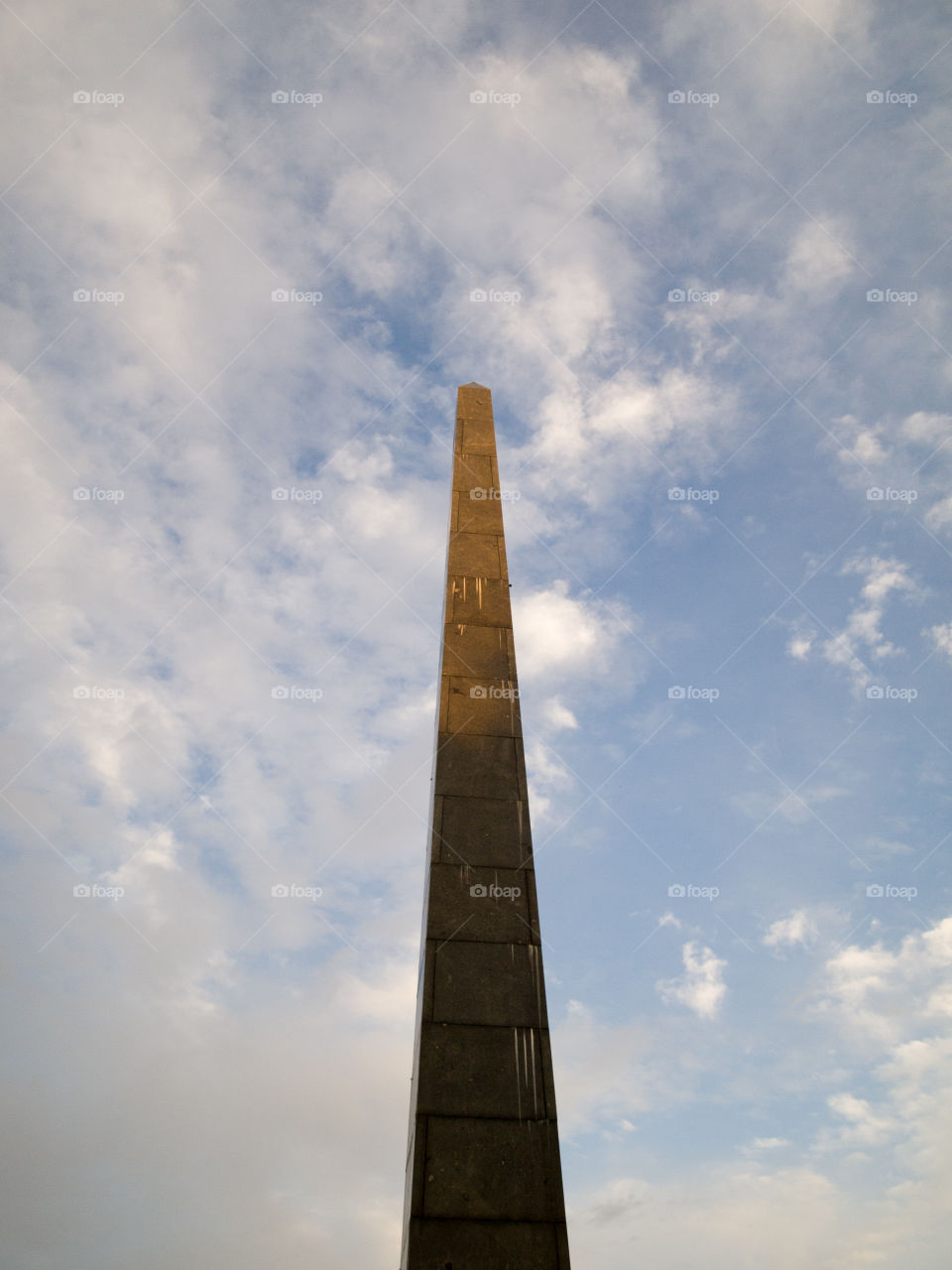 gray concrete cone-shaped monument under a blue sky with white clouds 4