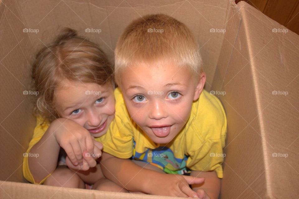 Brother and sister inside cardboard box