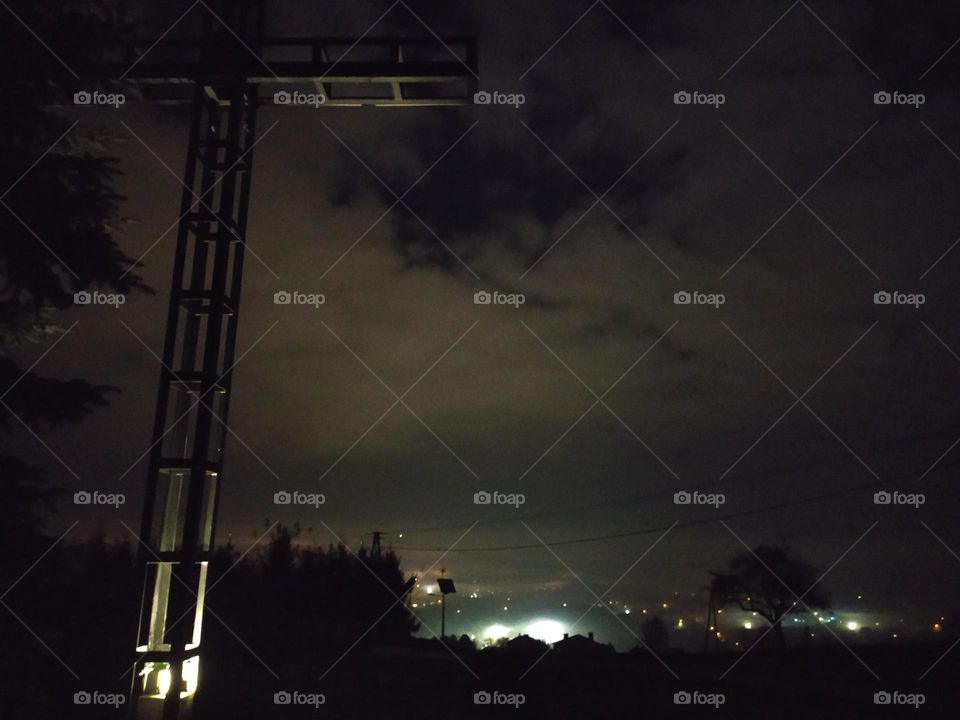 Night City on the background of an illuminated cross