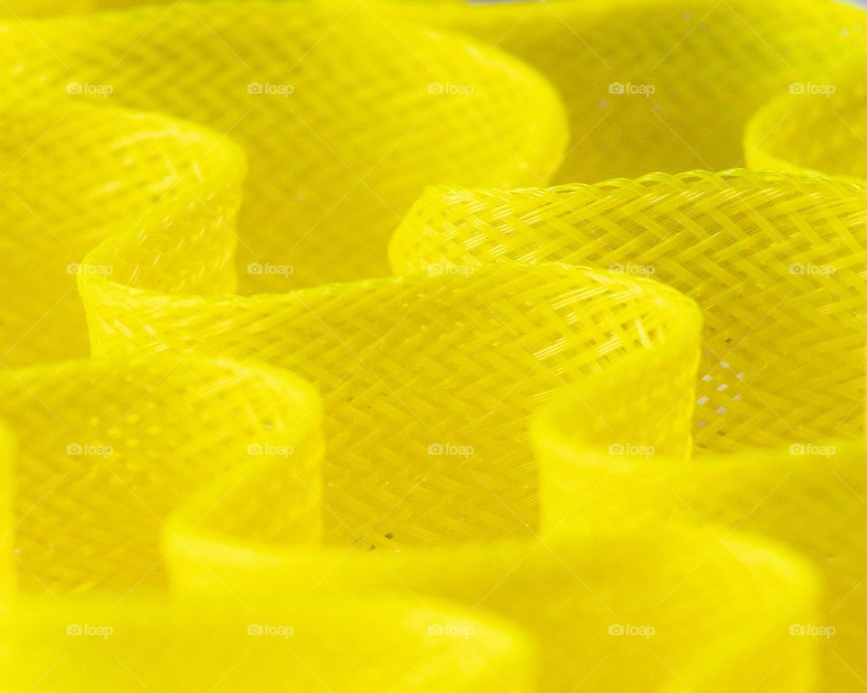 Yellow, woven hair curlers; macro