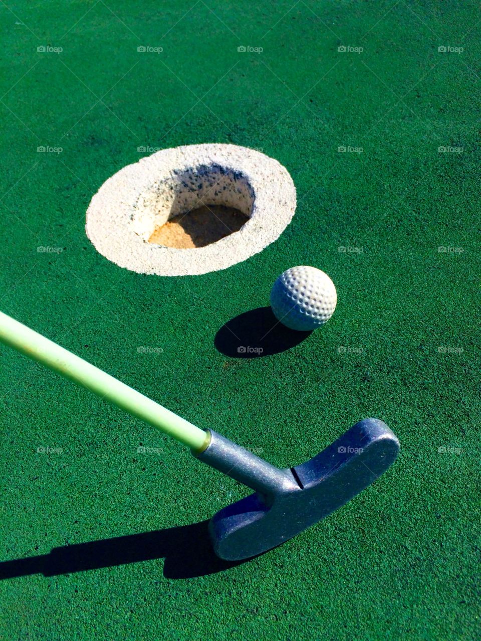 Putter and ball on green