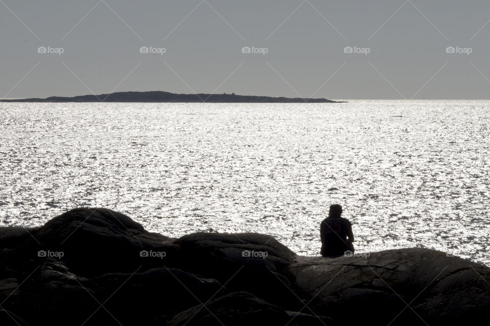 A man sitting looking out over the sea