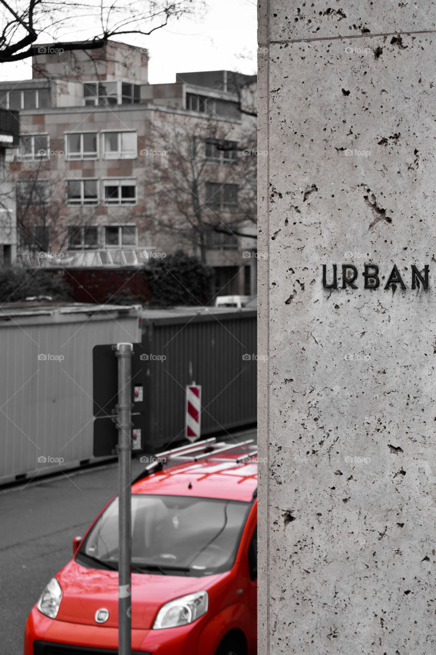 city scene with red car and the word urban on a wall