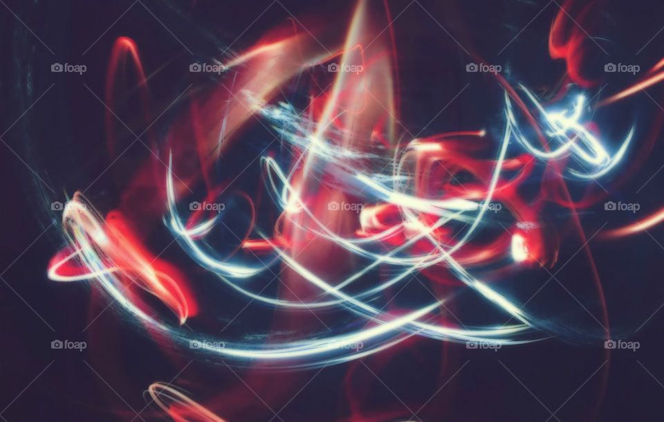 white and red light trail forming an abstract pattern in a dark setting