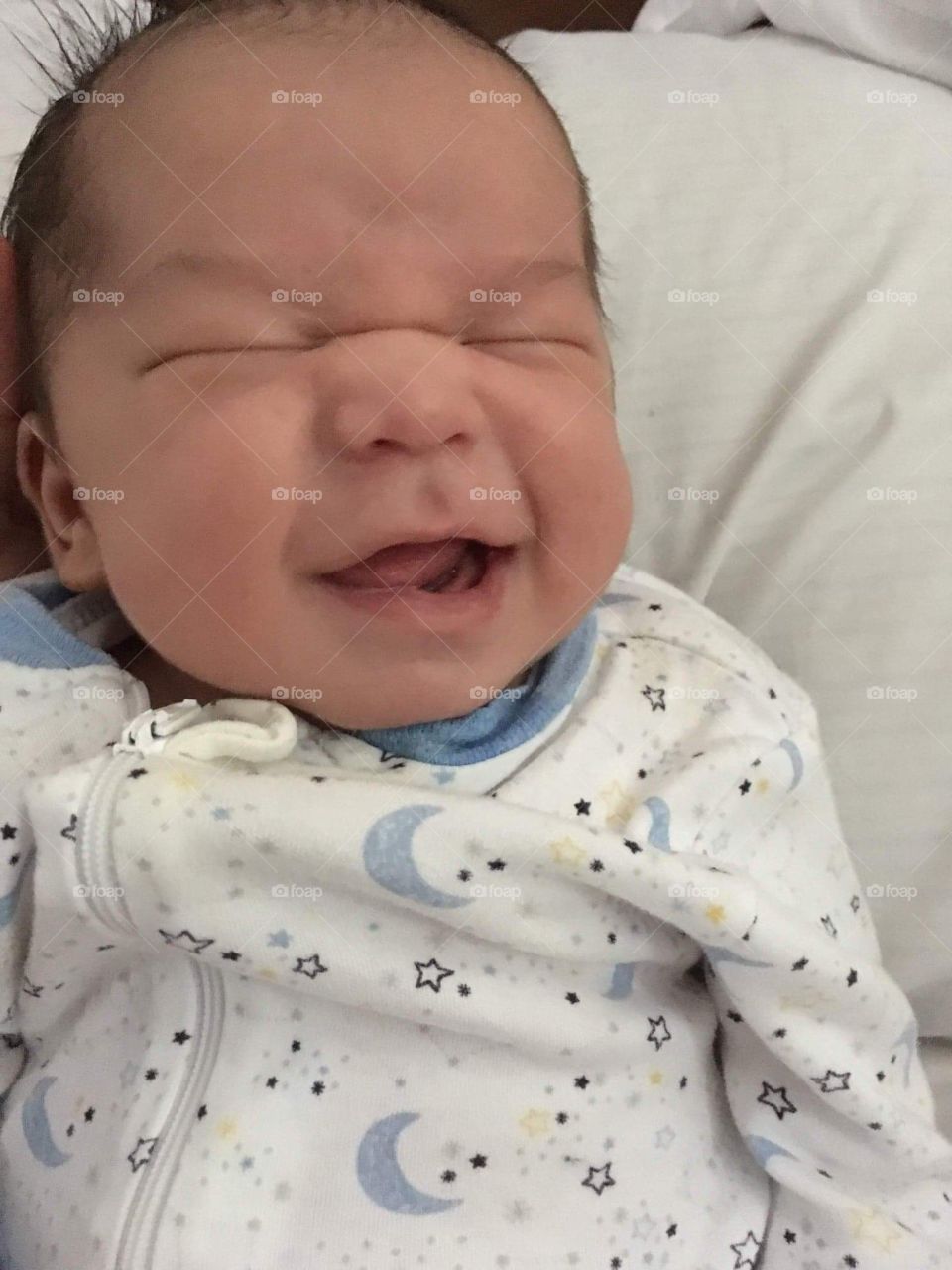 Baby smiling with eyes closed.