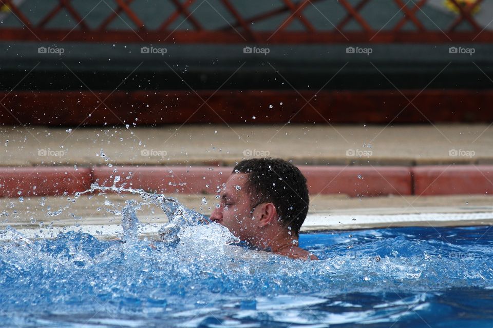 Young man swimming in pool 