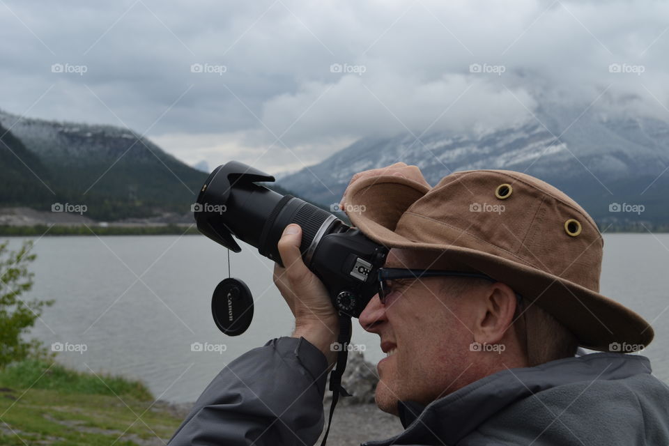 Young photographer photographing in mountain valley