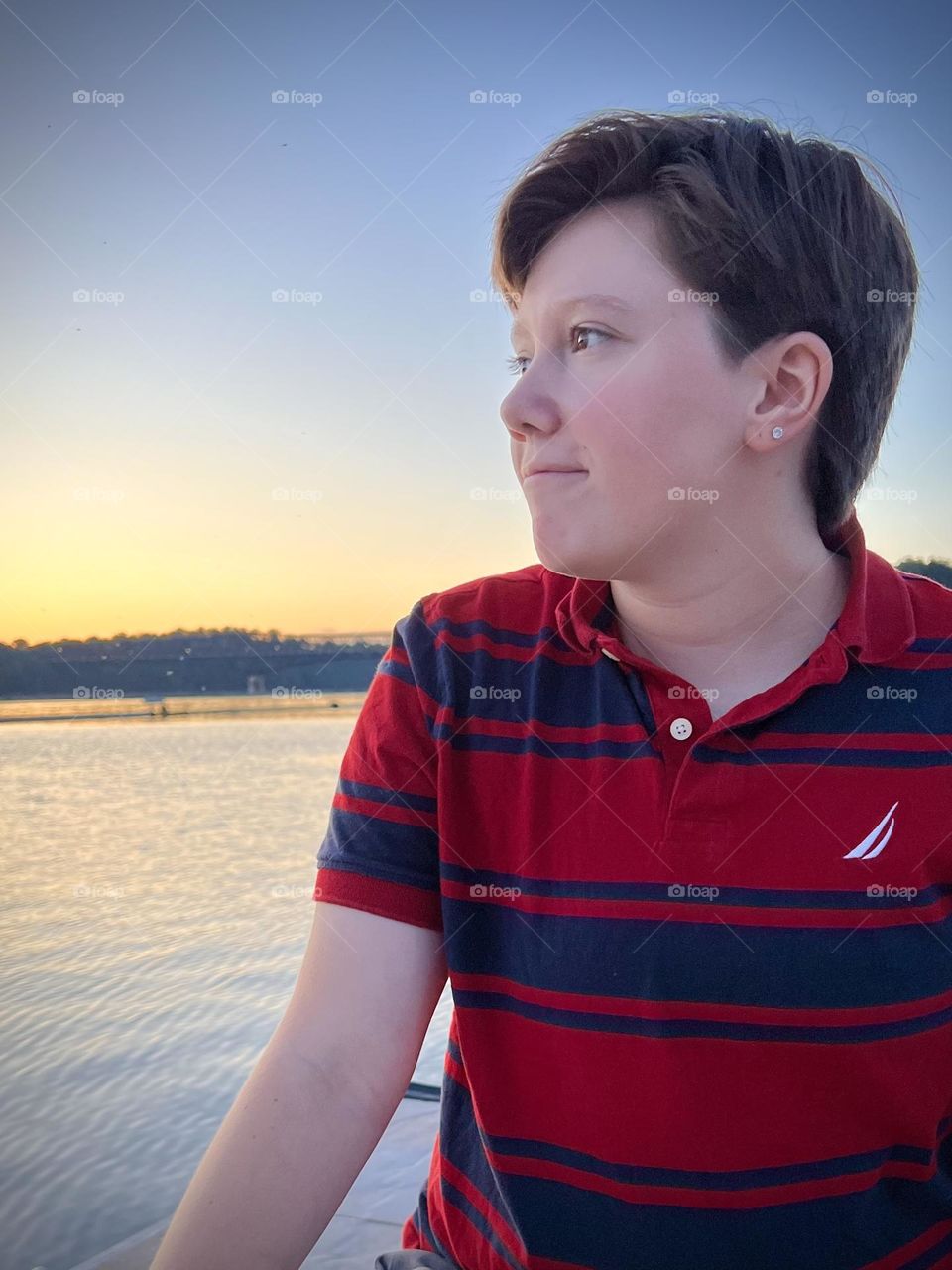 Teenager boy sitting on a dock