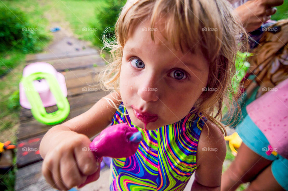 Little girl enjoying pink ice cream