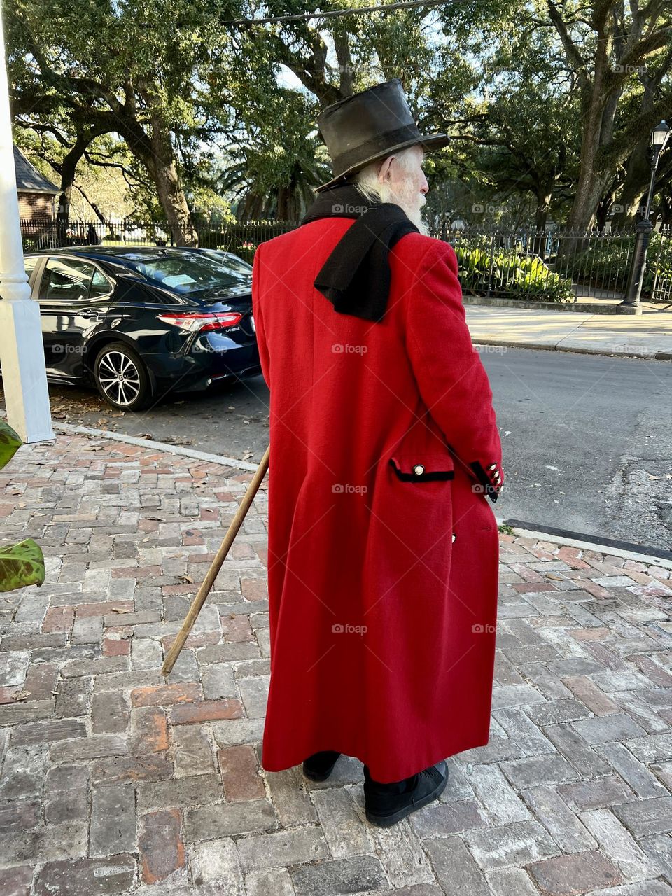 Mature man with red o overcoat and black tuba hat 