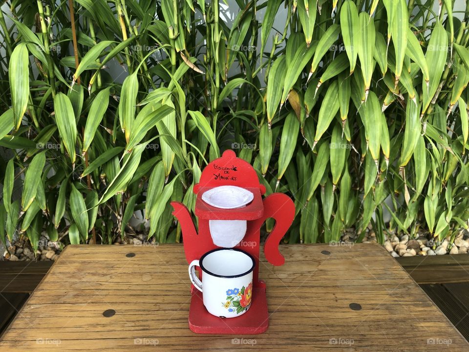 Cup of coffee in front of a green wall