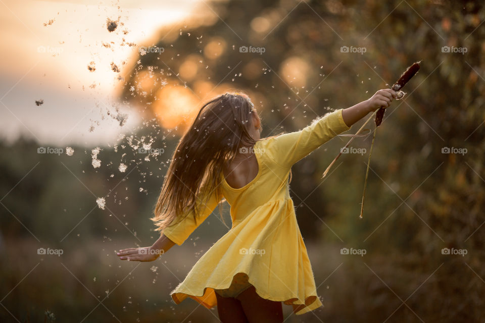 Little girl in yellow dress outdoor portrait at sunset 