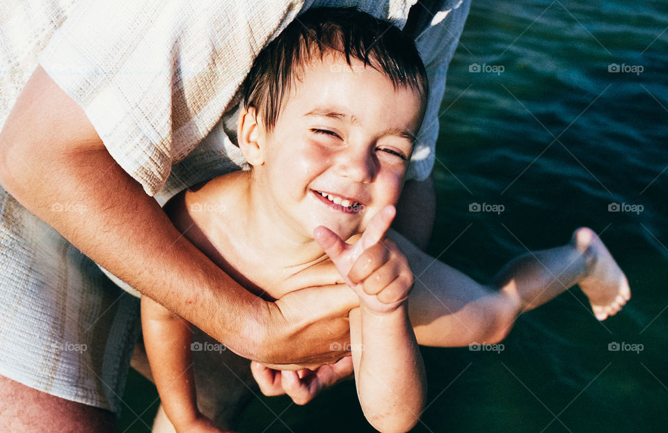 Father playing with his son. Father playing with his little son in the sea