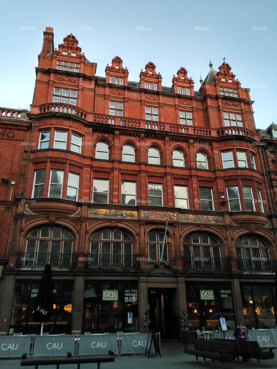 A red brick building with the sun shining in its windows, Liverpool, England.  A sunny and beautiful winter day with clear sky.