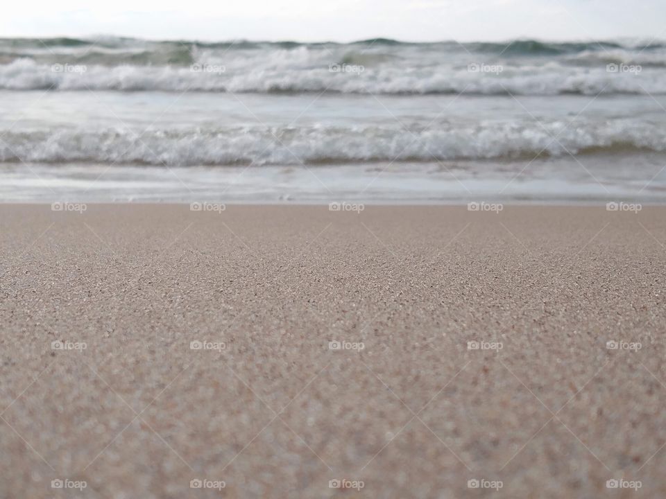 Unfiltered, beautiful close-up of the sand and waves at a beach