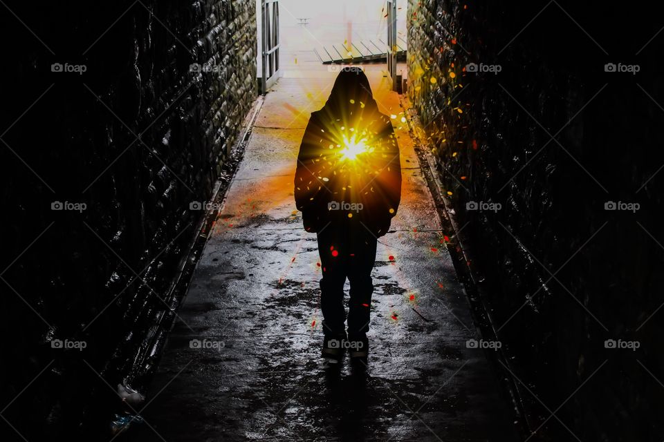 Glowing silhouetted boy in an underground tunnel