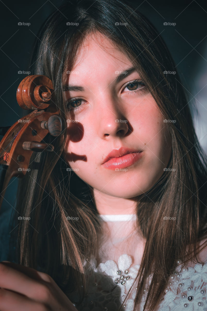 Girl holding a violin in the house