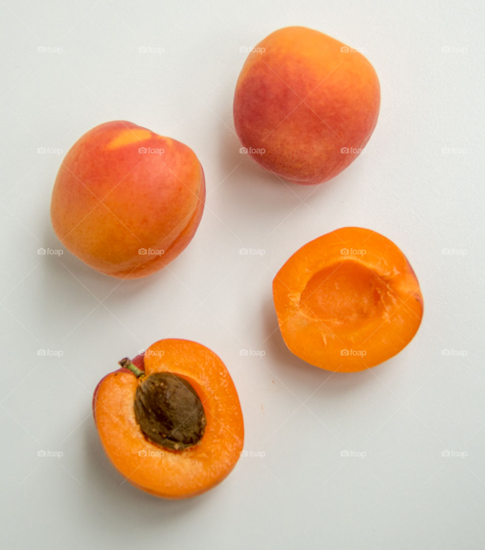 Sliced and whole apricots against white background
