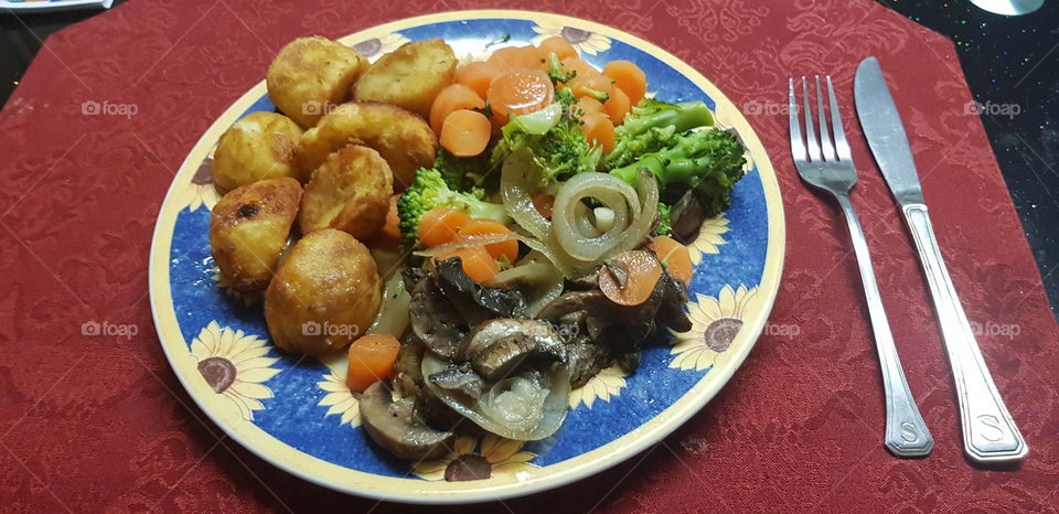 Steak dinner with potato carrots broccoli and onions