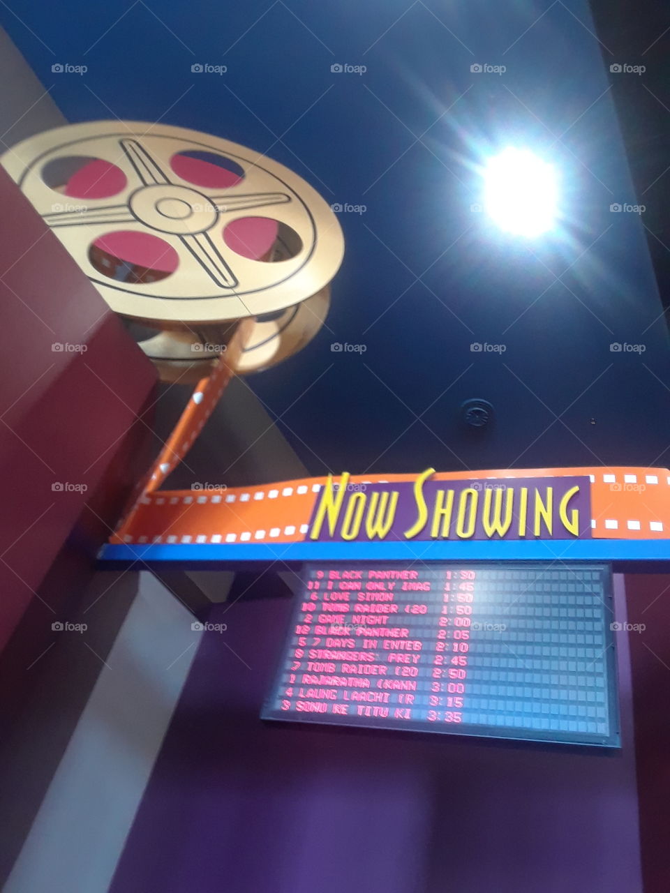 now playing for your grand movie.Film work.watching a great movie to keep u occupied and busy with life.i get in free haha lol.Gotta love the theater colors and attraction. nice light to go with it.action photo.