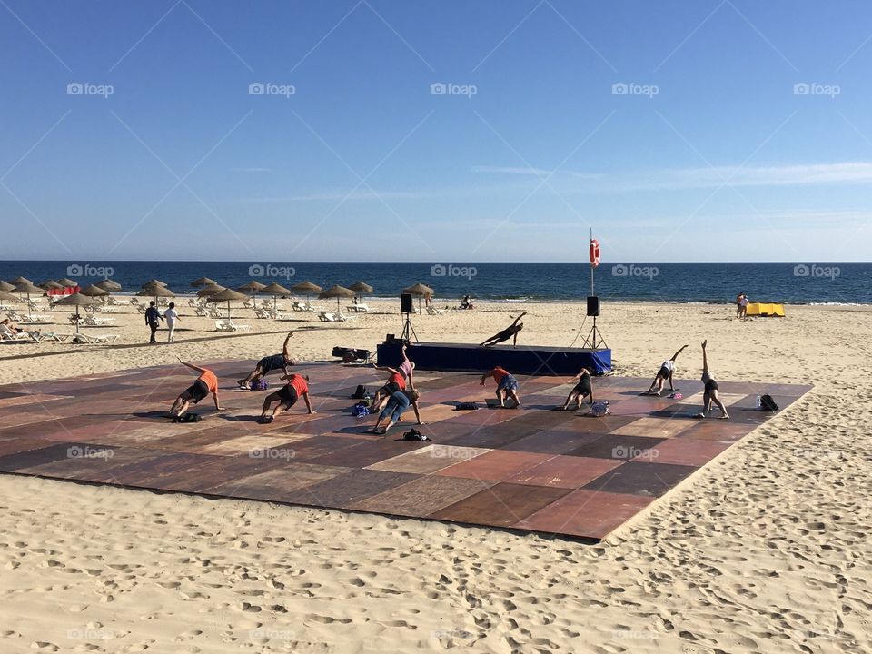 Yoga lesson on beach with social distance 