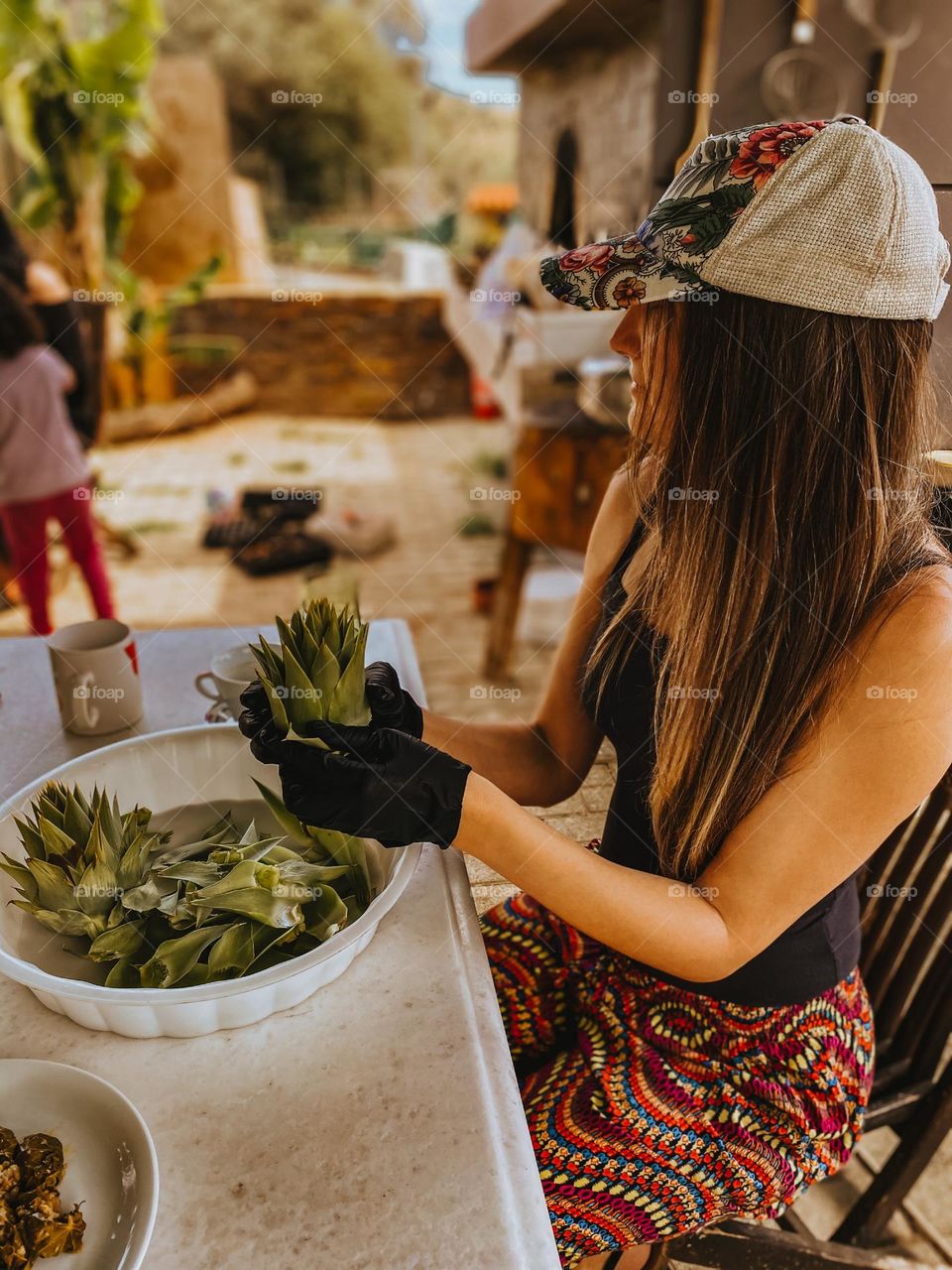 Young woman sits at the table and cleaning vegetable 