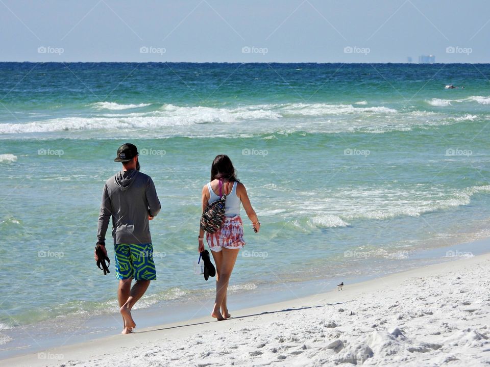 Life in Motion - A young couple takes a stroll on the sandy beach in front of the Gulf of Mexico