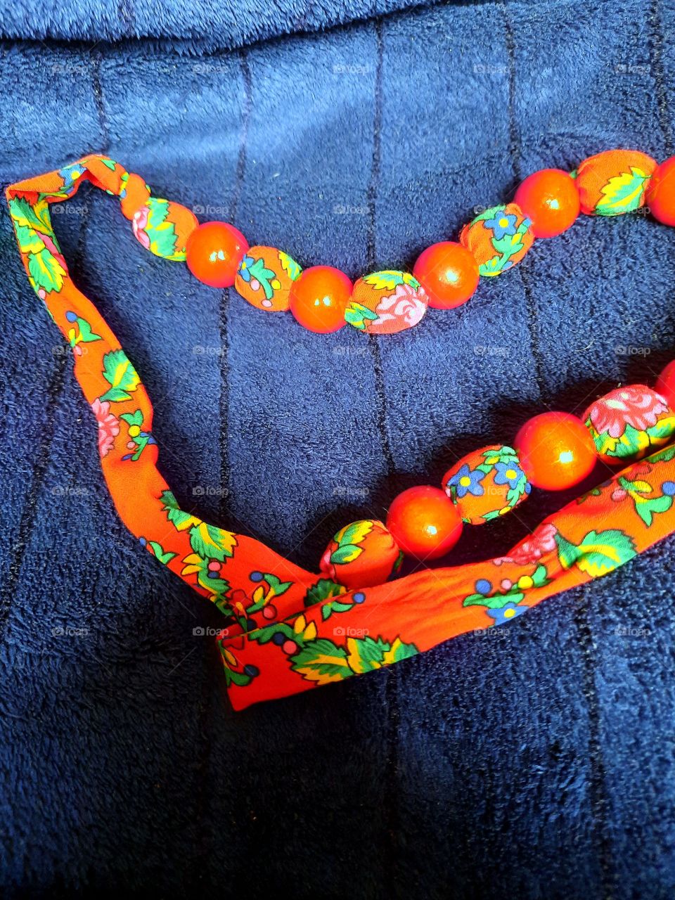 orange folk necklace on blue background