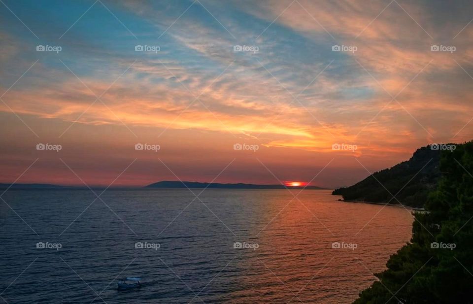 Let the vibrant hues of the sunset paint your worries away as the day gracefully melts into the horizon