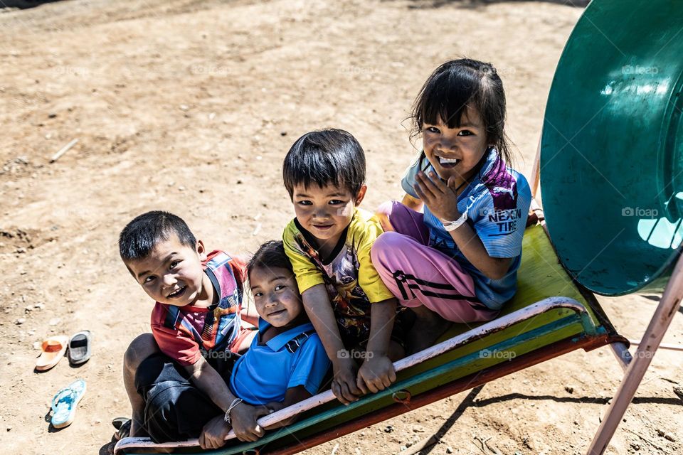 4 School kids on the slide in the school playground