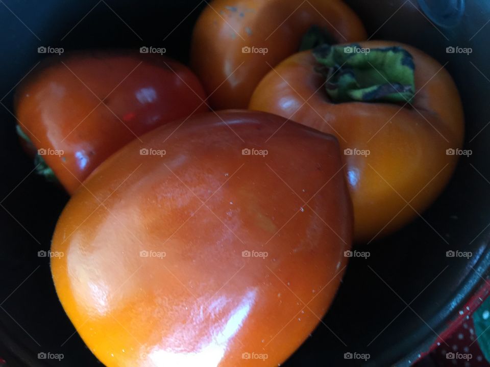 Four persimmons in bowl