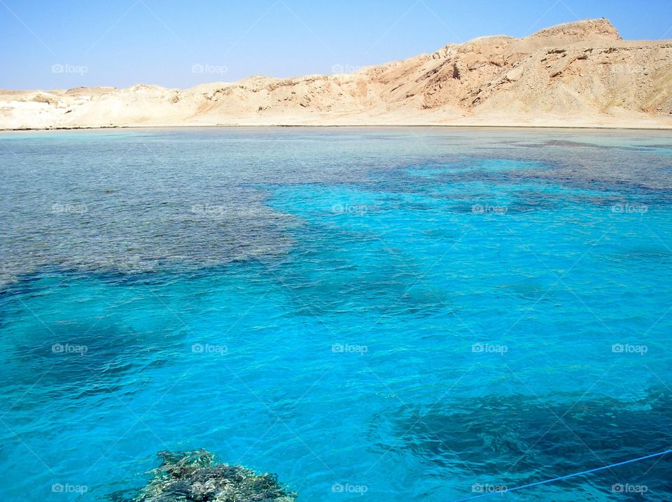 Coral reefs in the sea and rocky hills on the skyline 