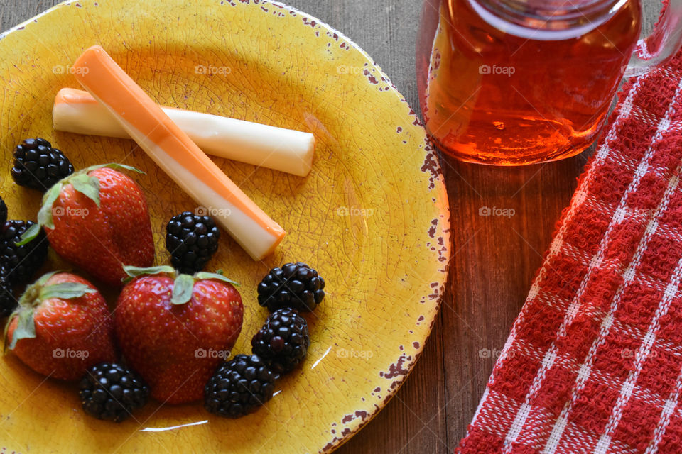 Cheese sticks and fruit with a glass of juice