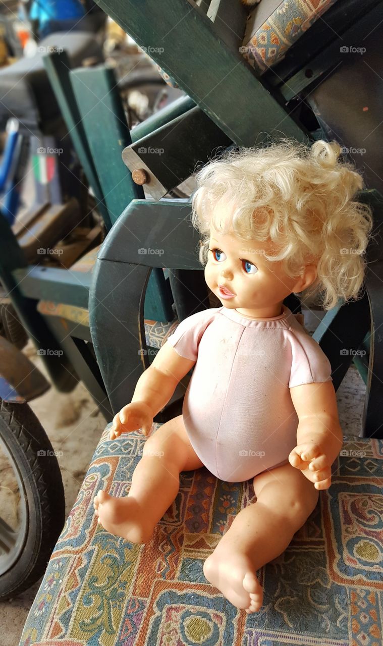 old doll forgotten in a pile of mess
