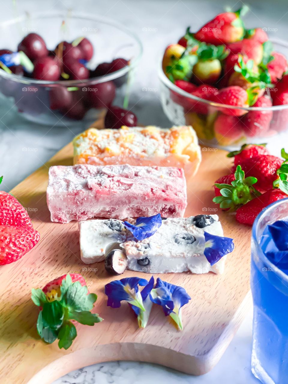 Frozen yogurt bark and some fresh strawberries at the side. 