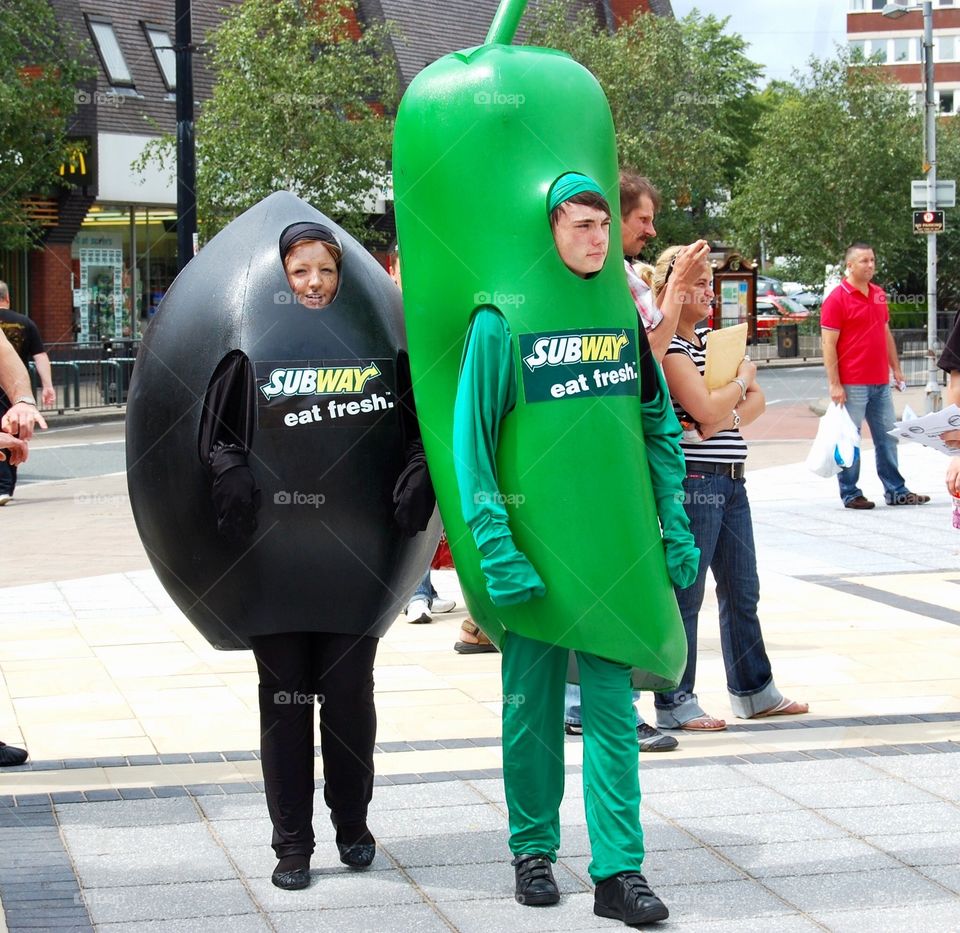 Two people paid to dress up as an olive and a chili pepper or gherkin to advertise Subway. 