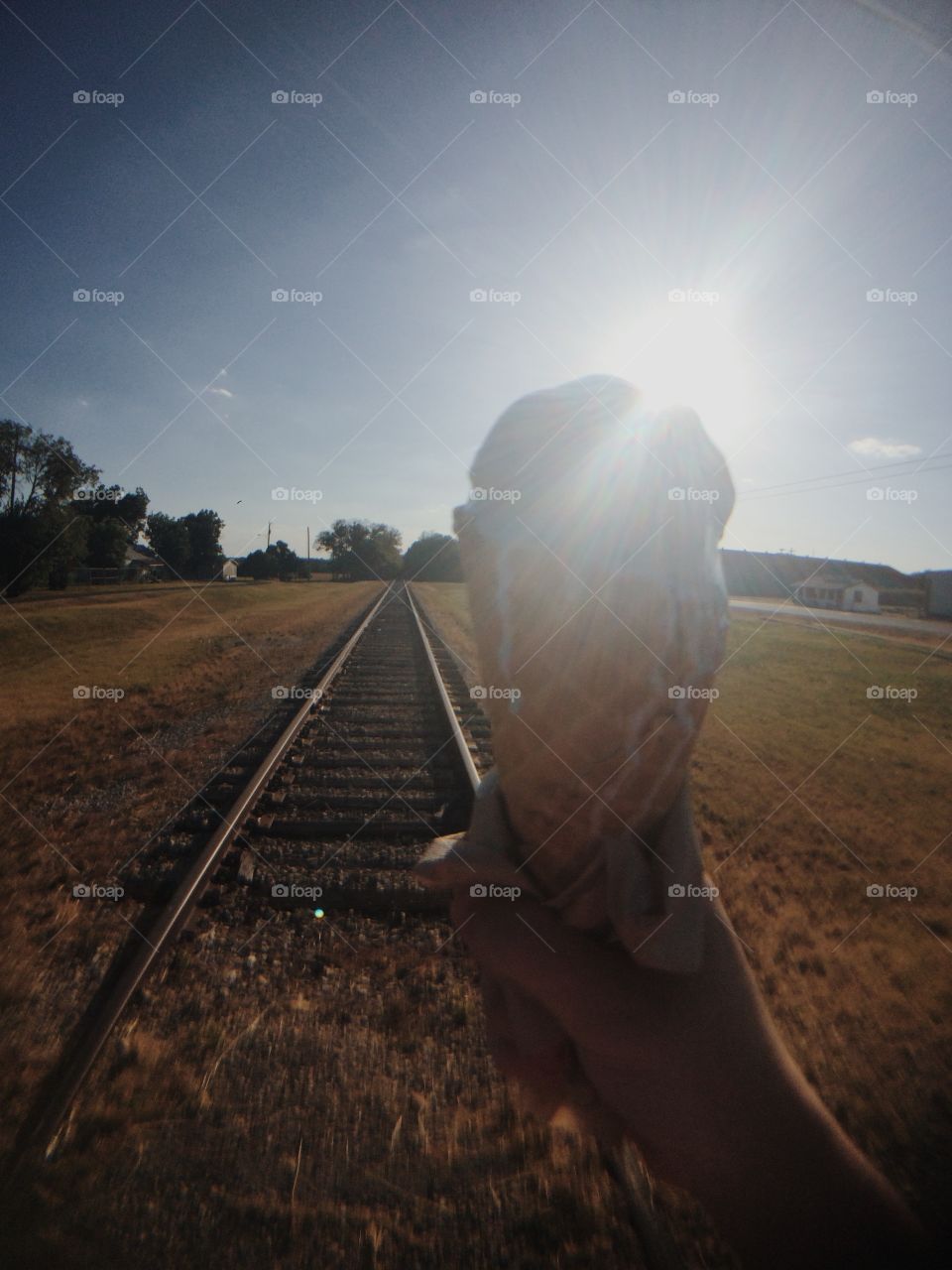 Ice cream & Train tracks. Hand holding ice cream in Texas