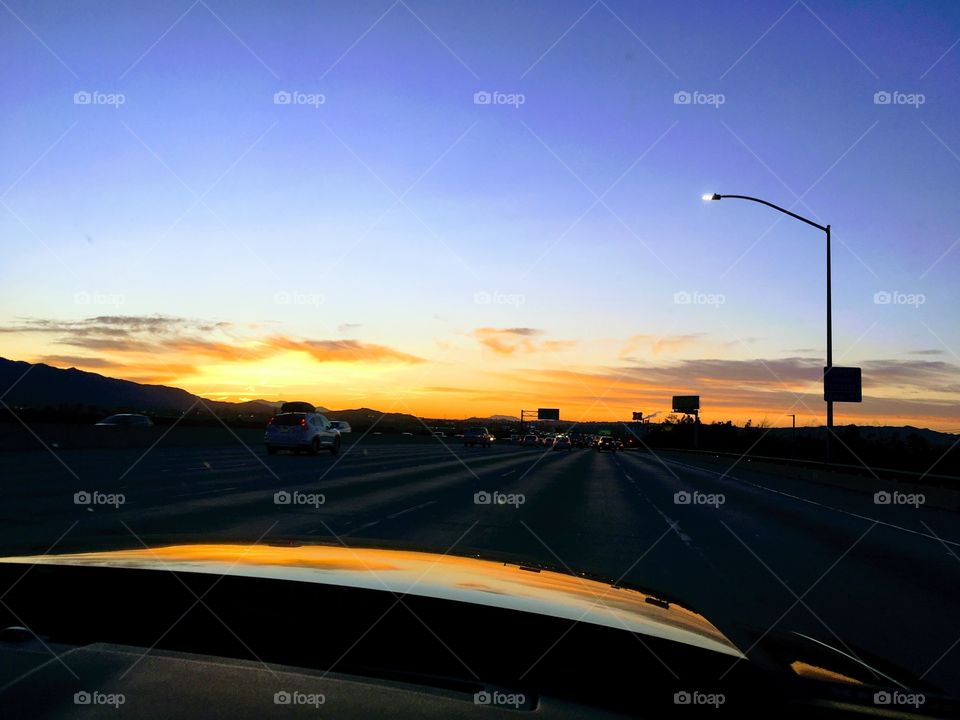 Sunrise reflected on car hood on freeway to Las Vegas.
