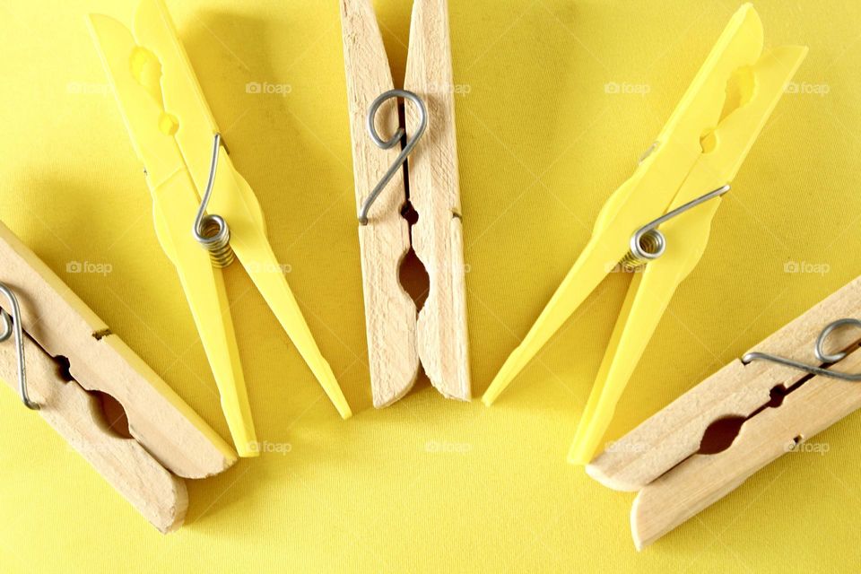 clothespins in symmetry on a yellow background
